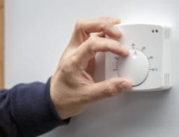 központi fűtés termosztátot állítja be egy férfikéz
