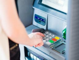Egy nő ATM-ből vesz fel készpénzt.
