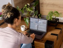 Egy nő a laptopján ellenőrzi bankszámlája banki díjait a notebook-ján.