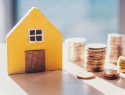 miniatűr házikó és pénzérmék - átlagfizetésből felvett lakáshitel