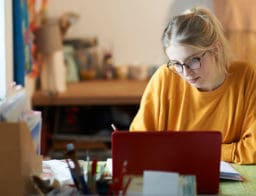 egyetemista lány asztalnál, tablettel, diákszámla online megnyitása közben