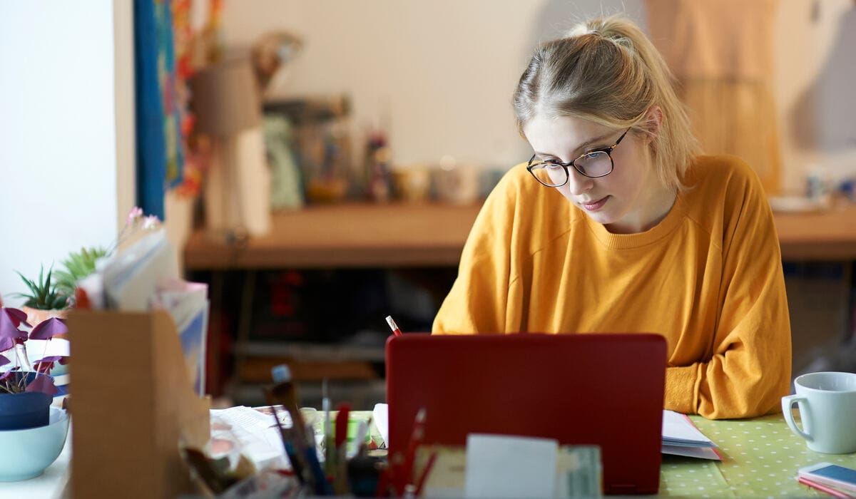 egyetemista lány asztalnál, tablettel, diákszámla online megnyitása közben