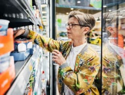 élelmiszer-infláció a boltban: idősebb hölgy a tejtermékek között válogat