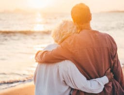 nyugdíjas házaspár a tengerparton, nyaralás közben, naplementében, nyugdíj megtakarítással a bankszámlájukon