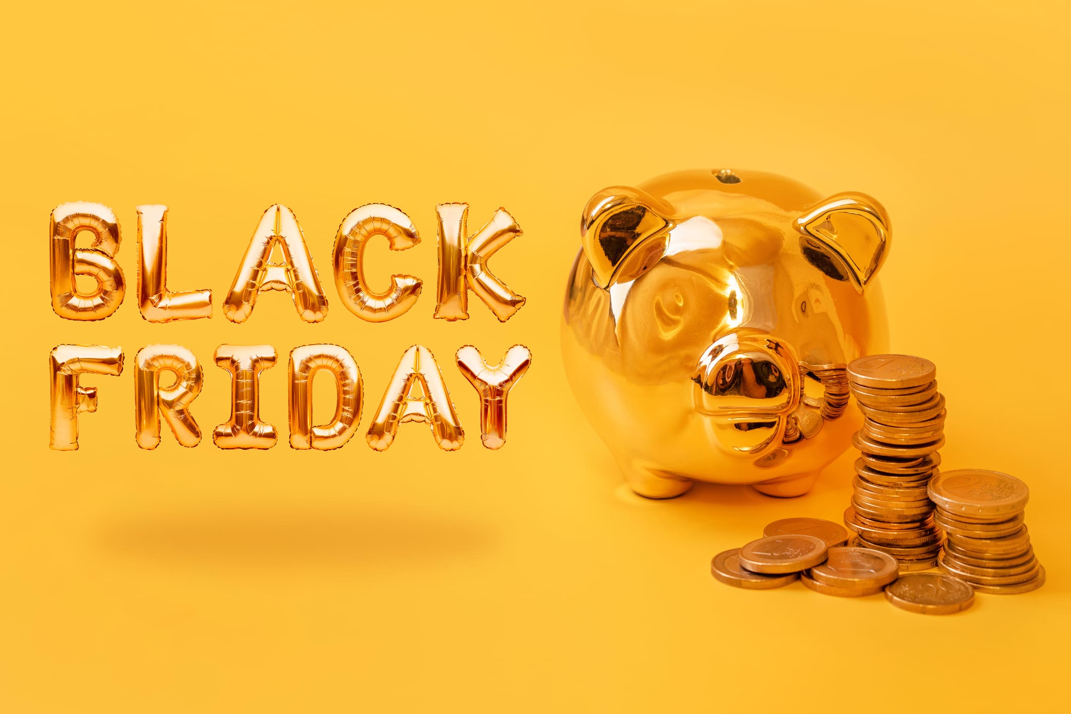 Black Friday pénzvisszatérítési akciók - arany malacpersely mellett pénzérmék, és black friday felirat betűlufiból