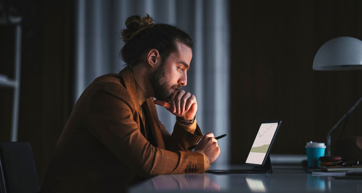 férfi laptop előtt részvényelemzés közben