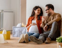 fiatal pár, terhes feleség csok pluszos új lakásban a földön ülnek