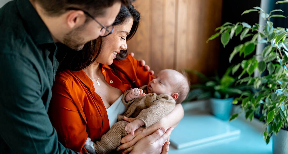 30 alatti fiatal házaspár babával a kezében, babaváró hitel felvétele előtt
